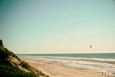 two person playing kite on seashore thumbnail