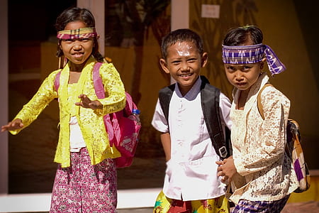 closeup photo of three children walking on street during daytime thumbnail
