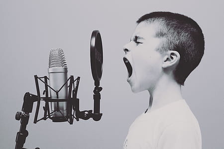 grayscale photo of boy singing in front of condenser microphone with pop filter thumbnail