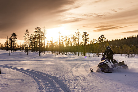 person riding on snow mobile during day time thumbnail
