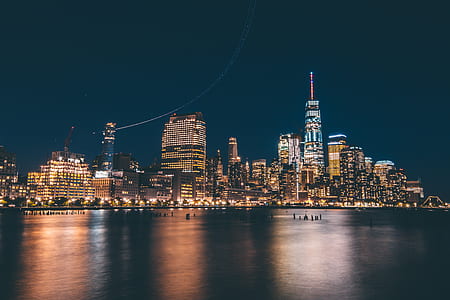 body of water near buildings during night thumbnail