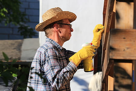 man mending brown wall thumbnail