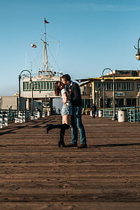 man kissing woman on dock during daytime thumbnail