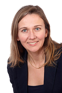 smiling woman wearing black suit jacket and gold-colored necklace thumbnail