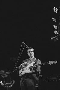 grayscale photography of man playing electric guitar thumbnail