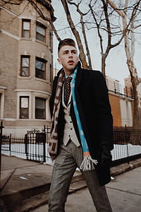 man walking on gray concrete pathway near brown concrete building at daytime thumbnail