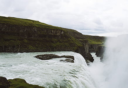 waterfalls near mountains at daytime thumbnail