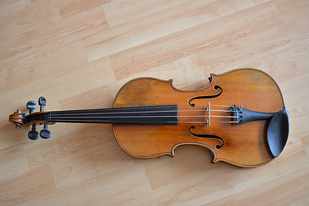 brown and black violin on brown parquet floor during daytime thumbnail
