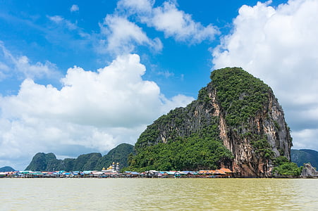 rock isles beside village during daytime panoramic photo thumbnail