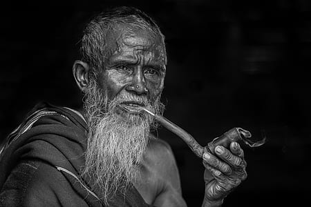 man holding tobacco pipe grayscale photograph thumbnail