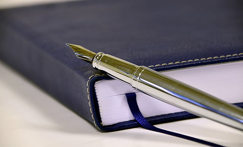 silver fountain pen on top of black leather covered book thumbnail