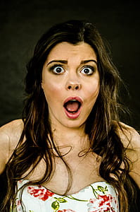 woman in shock face wearing white, green, and red floral sweetheart dress \ thumbnail
