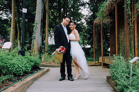 groom and bride standing in the middle of garden aisle thumbnail