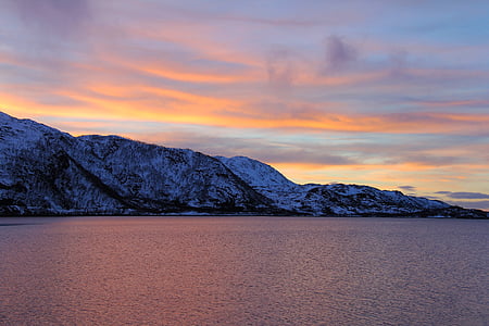 mountain beside body of water during golden hour thumbnail