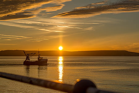 silhouette of boat during golden hour thumbnail