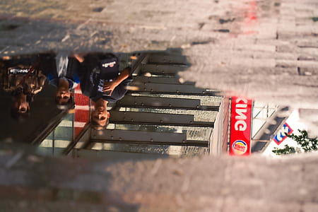 water puddle reflecting group of people thumbnail