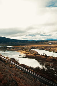 body of water, next to road during daytime thumbnail