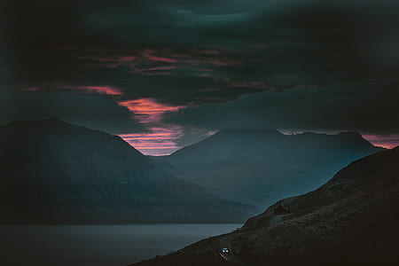 two mountains beside a body of water during sunset thumbnail