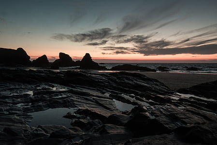 landscape photography of rocks in front of body of water thumbnail