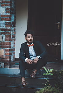 Man Sitting Near Brown Door thumbnail