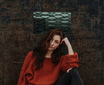 woman wearing red sweatshirt sitting down resting head on left hand thumbnail