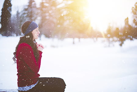 woman sitting while praying during golden hour thumbnail