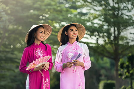 two women in pink cheongsam dresses during daytime thumbnail