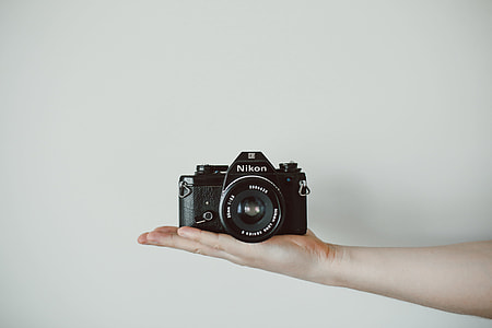 black Nikon camera on person hand thumbnail