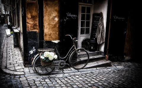gray commuter bike parked beside black building thumbnail