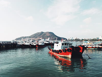 red and white towboat on calm body of water under white couds thumbnail