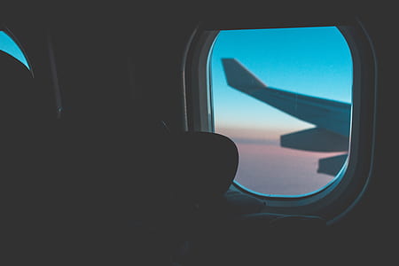 silhouette photo of person in plane looking window thumbnail