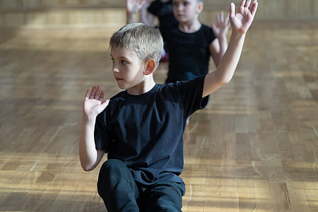 boy sitting on parquet floor raising his hands thumbnail