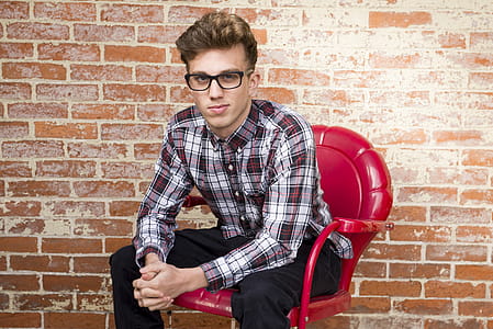 Man In Dress Shirt Sitting On Red Armchair thumbnail
