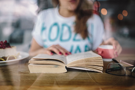 Woman reading book at coffee shop thumbnail