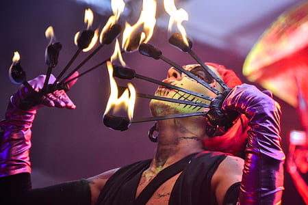 Red Haired Fire Dancer Blowing Rod With Flames thumbnail