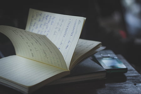 black candybar phone beside book on table thumbnail
