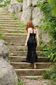 woman in black dress standing on staircase thumbnail