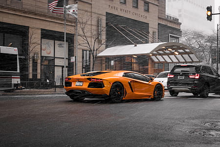orange Lamborghini Aventador park behind BMW X5 SUV during daytime thumbnail