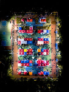 aerial photography of assorted-color canopy tents on green and brow field at night thumbnail