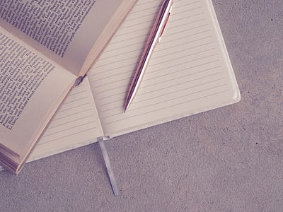 white ruled paper and brown pen on brown surface thumbnail