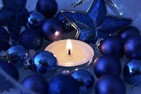 close up photography of lighted tealight candle surrounded with blue baubles thumbnail