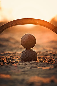 shallow focus photography of round stone mounted on black stone during sunset thumbnail