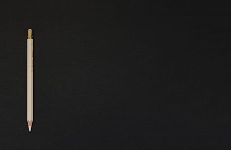 beige pen on black background thumbnail