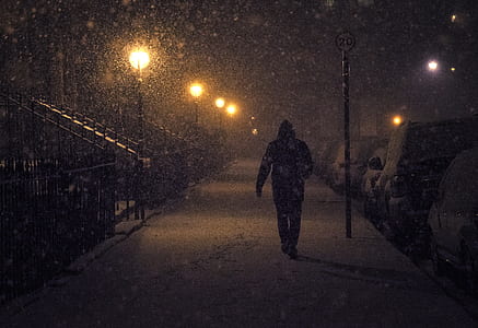 man walking at sidewalk during snow thumbnail
