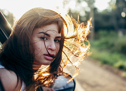 woman riding vehicle while head is out thumbnail