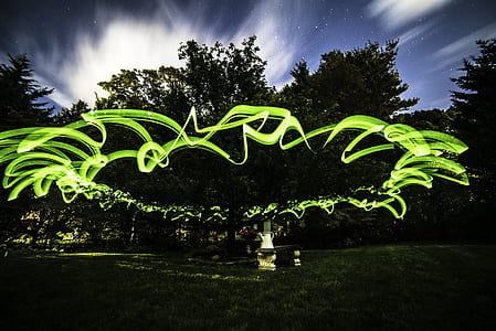 time lapse photo of green light and trees during nighttime thumbnail