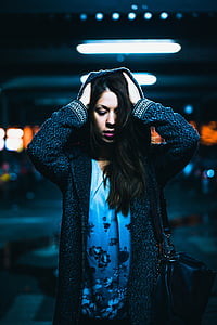 woman wearing black hooded jacket touching hair with both hands thumbnail
