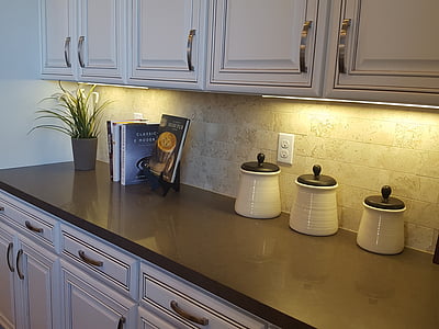 three white-and-brown ceramic jars with lids on black granite top thumbnail