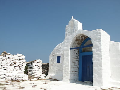 white concrete building with blue door near concrete brick wall thumbnail