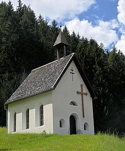 white and brown concrete chapel on green grass hill thumbnail